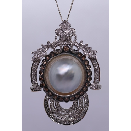 40 - 18ct white gold pendant centrally set with a mabe pearl surrounded by champagne diamonds & borde... 