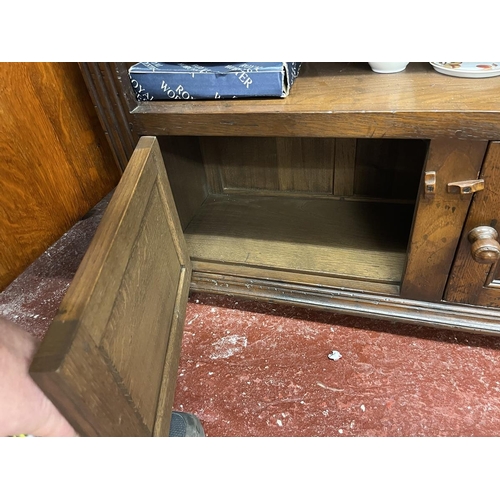 550 - Long open carved oak bookcase with cupboards to base