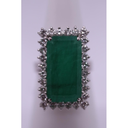 63 - 18ct white gold ring set with large rectangular 10ct emerald bordered by fine diamonds - Size N