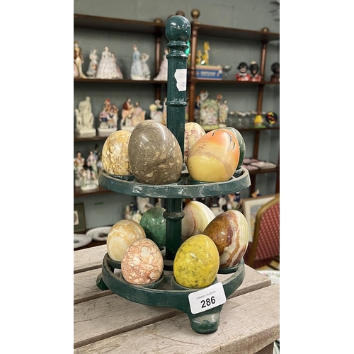 286 - Cast iron egg stand together with a collection of onyx stone eggs