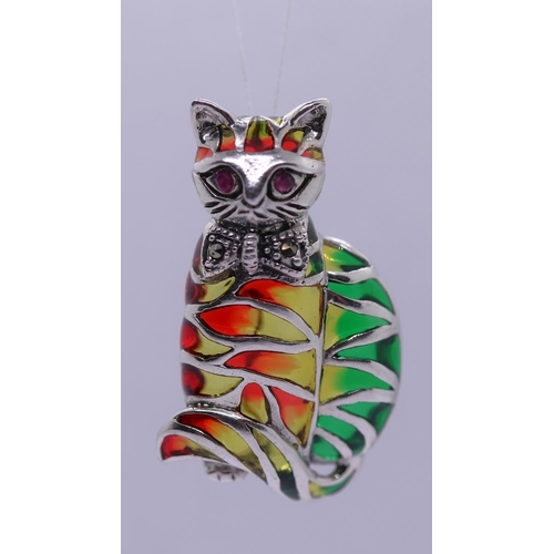 57 - Silver & enamel cat brooch/pendant with ruby set eyes