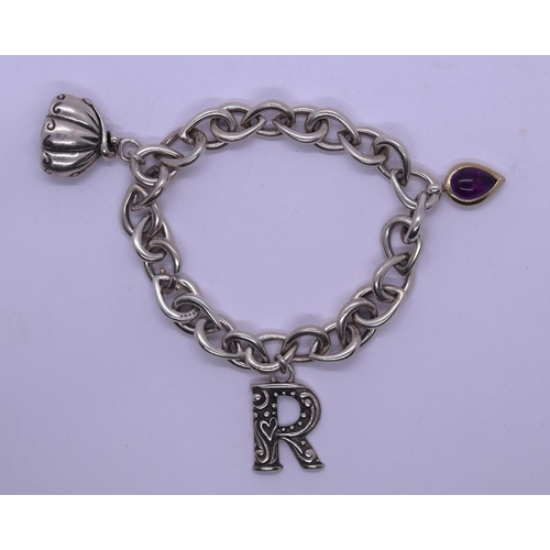 73 - Silver charm bracelet with tear drop shaped amethyst set charm