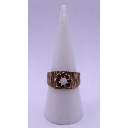 88 - Vintage bark effect 9ct gold ring with central white opal surrounded by 7 garnets. Size O - Approx g... 