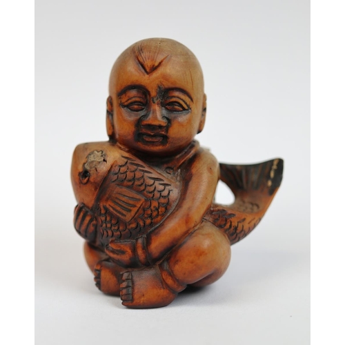 97 - Wooden Netsuke of boy holding fish - signed to base