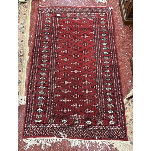 648 - Red patterned rug - Approx size 157cm x 94cm