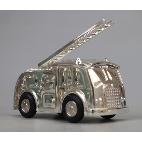 12 - Silver plated fire engine money box together with pair of silver plate firemans helmet scuttles, 1 w... 