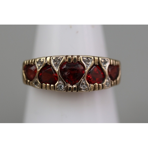125 - 9ct gold 5 heart shaped garnet set ring, plus small white (diamond like) stones surrounding, and ben... 
