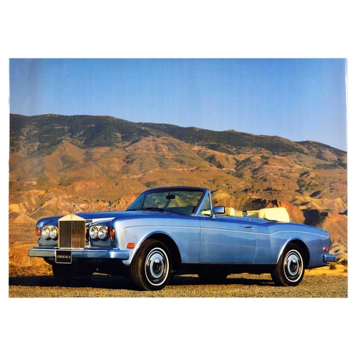 Advertising Poster Corniche II Rolls Royce Mountain Road Luxury Automobile. Original vintage advertising poster for Rolls-Royce Corniche in blue on a mountain road. Corniche II is a two-door convertible car produced from 1986 to 1989. Rolls-Royce was a British manufacturer of luxury cars and later aero-engines, the company was founded in 1904 by a Welsh motoring and aviation pioneer Charles Rolls (1877-1910) and an English engineer Henry Royce (1863-1933). Horizontal. Excellent condition, minor creasing. Country of issue: UK, designer: Unknown, size (cm): 60x84, year of printing: 1980s