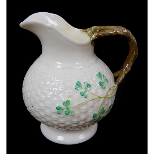 6 - Belleek Porcelain - Shamrock shape, two cream jugs with bifurcated crabstock handle; and a sugar bow... 