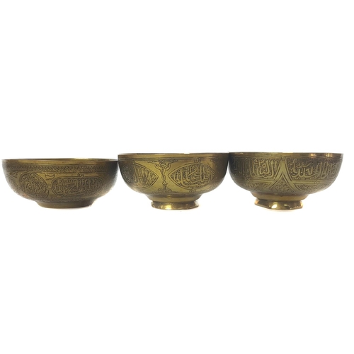 38 - Three Islamic brass bowls, chased with panels of Islamic or Arabic script within strapwork with foli... 