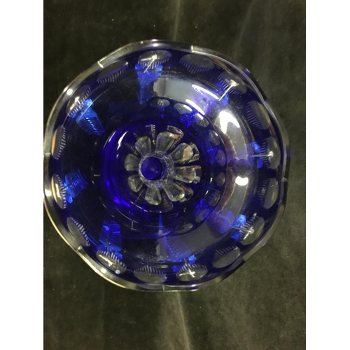 43 - A blue overlay glass lustre, of bud form on trumpet foot, cut through to clear with roundels and flu... 