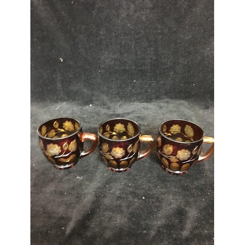 61 - Three bohemian glass punch cups of ruby cut through to amber with flowering vines; and Amberina punc... 