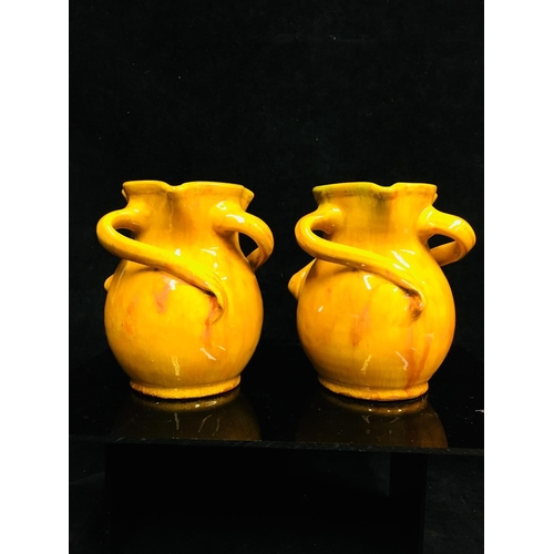 70 - A pair of Baron Barnstaple Pottery vases, each glazed in 'Liberty's Orange, of money purse form the ... 