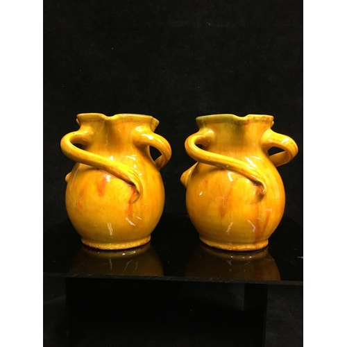 70 - A pair of Baron Barnstaple Pottery vases, each glazed in 'Liberty's Orange, of money purse form the ... 