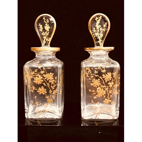 73 - A pair of Baccarat glass perfume bottles and stoppers, colourless glass of square section gilded wit... 