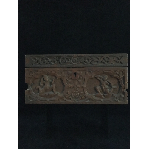 86 - An Indonesian carved wood box, decorated with a panel of figures and a tree within a scrolled border... 