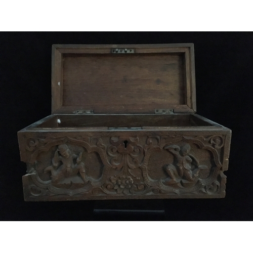 86 - An Indonesian carved wood box, decorated with a panel of figures and a tree within a scrolled border... 