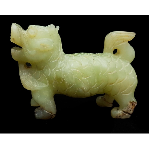 106 - A Chinese Jade figure, of pale green colour, carved as a Dog of Fo, standing four-square with erect ... 