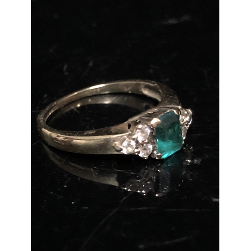 14 - An emerald and diamond set child's ring, the central synthetic emerald 4.64 x 3.85 approx split claw... 