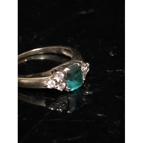 14 - An emerald and diamond set child's ring, the central synthetic emerald 4.64 x 3.85 approx split claw... 