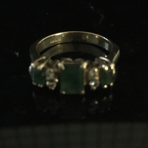 24 - An emerald and diamond half hoop ring, the three coloured stones of emerald cut interspersed with tw... 