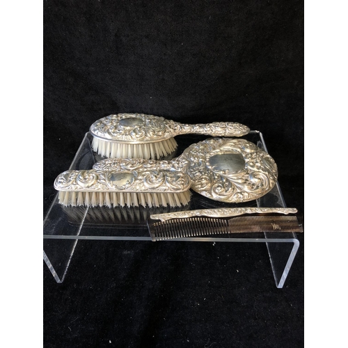 28 - A modern four-piece silver dressing table set, embossed in Victorian style with masks and foliate sc... 