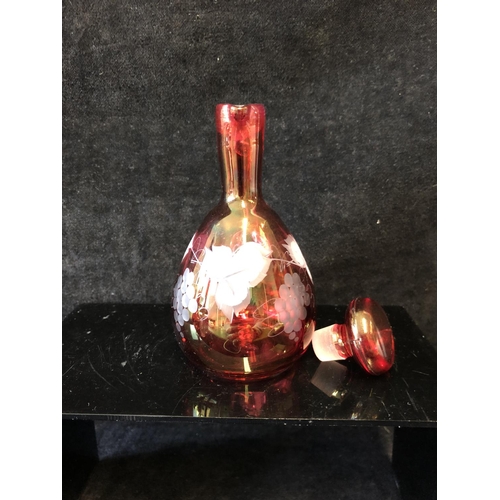 135 - A group of ruby and cranberry coloured glass ware comprising a cranberry claret jug; two cut beakers... 