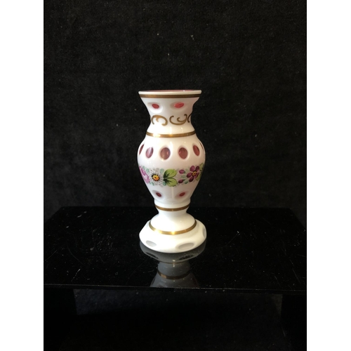 145 - A miniature Bohemian overlay glass vase, baluster form, cut with ovals from white overlay to cranber... 