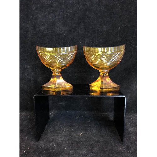 52 - Bohemian Glass - A pair of amber glass boat form pedestal salts, cut with hobnail banding and dentil... 