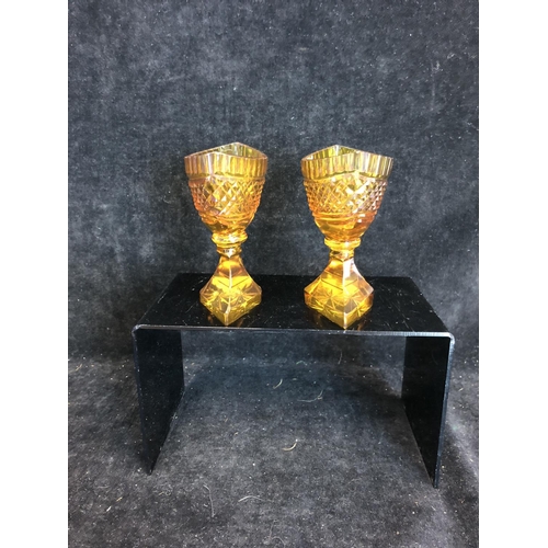 52 - Bohemian Glass - A pair of amber glass boat form pedestal salts, cut with hobnail banding and dentil... 