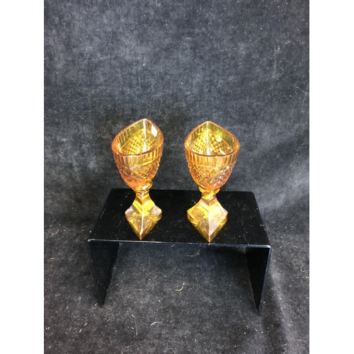 52 - Bohemian Glass - A pair of amber glass boat form pedestal salts, cut with hobnail banding and dentil... 