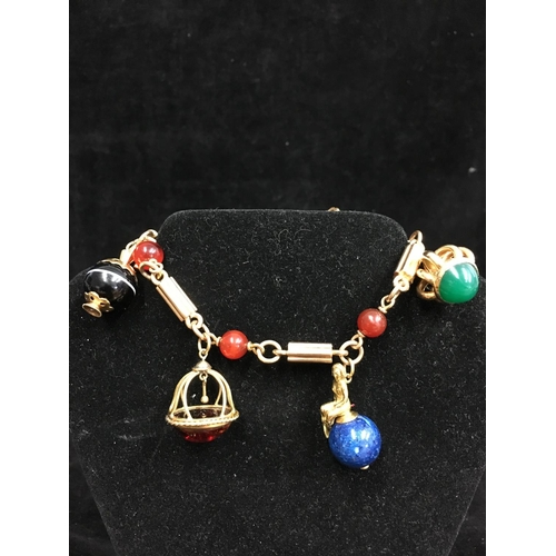 43 - An 18ct yellow gold charm bracelet in Victorian style, the bracelet formed of fluted bar links inter... 