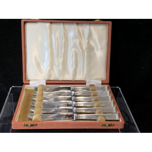 1 - A cased set of six silver handled butter knives, stylised reeded pistol handles, stainless steel bla... 