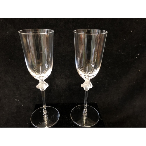 117 - Two Lalique Roxane pattern Champagne glasses, the stem knop formed as two female figures entwined ar... 