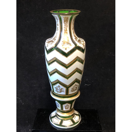 120 - A Bohemian Overlay glass vase, of baluster form, the white overlay cut through to emerald green in c... 