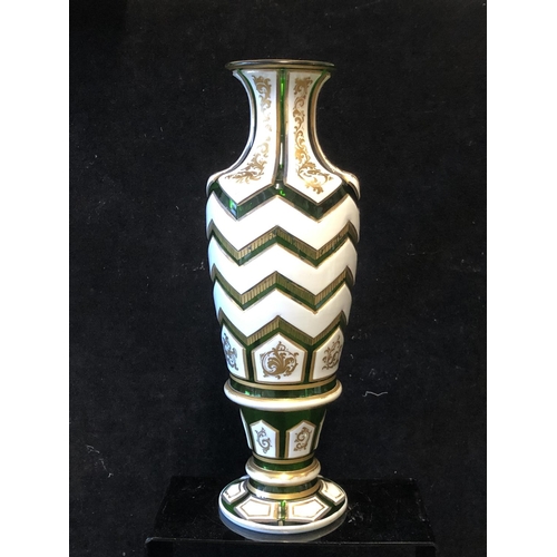 120 - A Bohemian Overlay glass vase, of baluster form, the white overlay cut through to emerald green in c... 