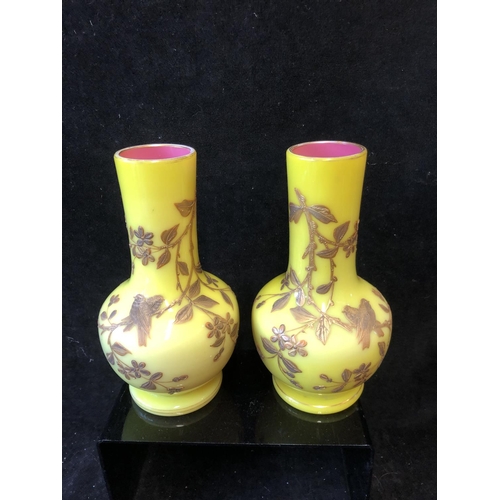 127 - A pair of Harrach overlay glass vases, of stout bottle form, yellow over shell pink, gilded with flo... 