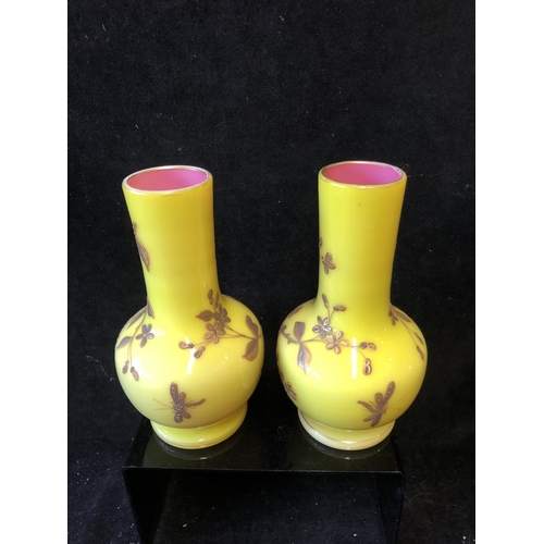 127 - A pair of Harrach overlay glass vases, of stout bottle form, yellow over shell pink, gilded with flo... 