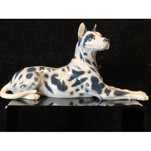 146 - Peter Herold for Royal Copenhagen Porcelain - A Great Dane dog figure, modelled reclining, grey spot... 