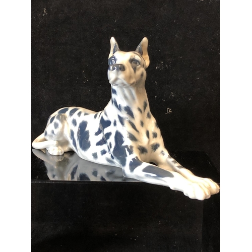 146 - Peter Herold for Royal Copenhagen Porcelain - A Great Dane dog figure, modelled reclining, grey spot... 