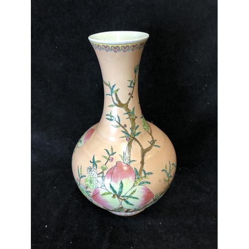 67 - A Chinese porcelain bottle vase, painted with peach fruit and flowers on a peach ground, red printed... 