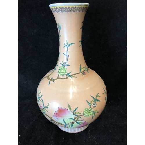 67 - A Chinese porcelain bottle vase, painted with peach fruit and flowers on a peach ground, red printed... 