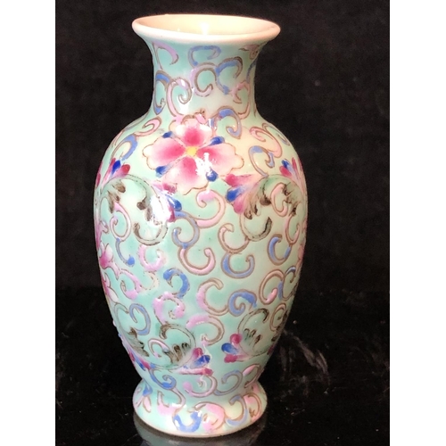 72 - A miniature Chinese famille rose porcelain baluster vase, decorated with scrolling peonies on a pale... 