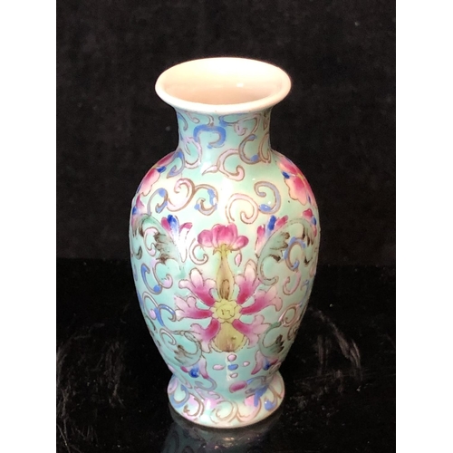 72 - A miniature Chinese famille rose porcelain baluster vase, decorated with scrolling peonies on a pale... 