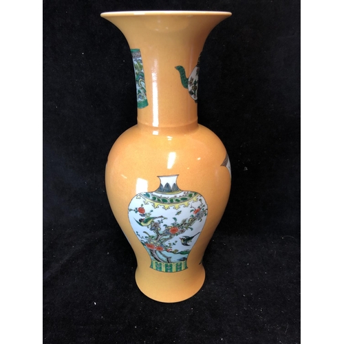 75 - A Chinese porcelain baluster vase, decorated with vases and teapots in famille verte pallete on an I... 