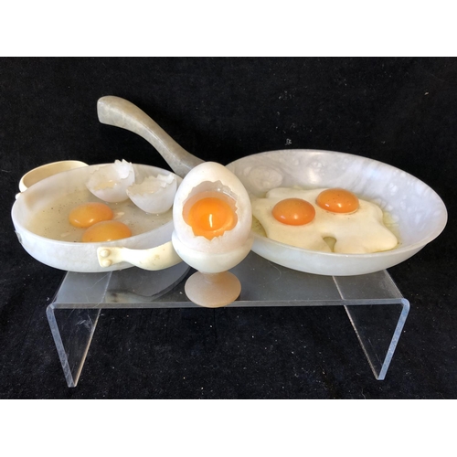 252 - Marco Ricciardi, Alabaster sculptures formed as fried eggs in av frying pan;  egg cup with cracked e... 