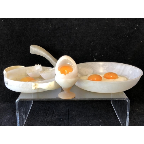 252 - Marco Ricciardi, Alabaster sculptures formed as fried eggs in av frying pan;  egg cup with cracked e... 