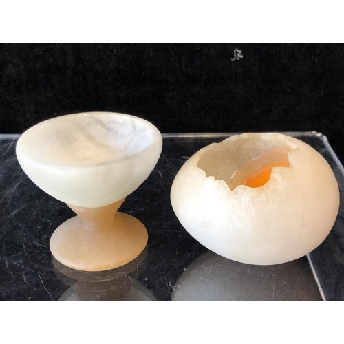 252 - Marco Ricciardi, Alabaster sculptures formed as fried eggs in av frying pan;  egg cup with cracked e... 