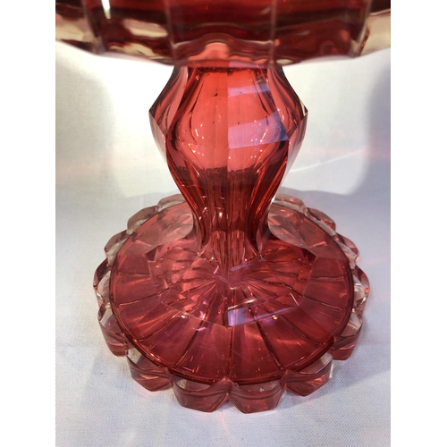 100 - Bohemian Glass - A large ruby glass centerpiece, the cased stand with hollow baluster stem, supporti... 