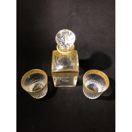 60 - Saint Louis - a Thistle Pattern decanter and stopper; and two tumblers, banded in gold with scrollin... 